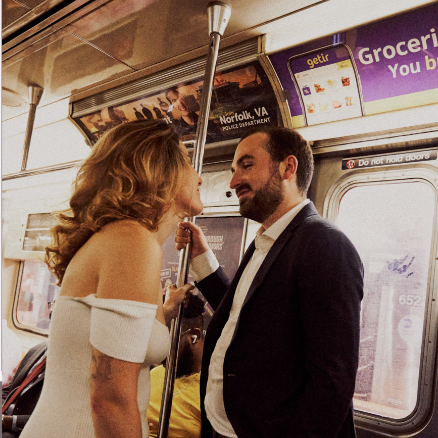 Man and woman in formal attire on a subway train